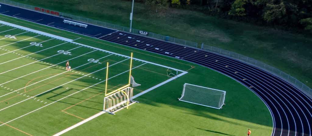 Football resting on green artificial turf