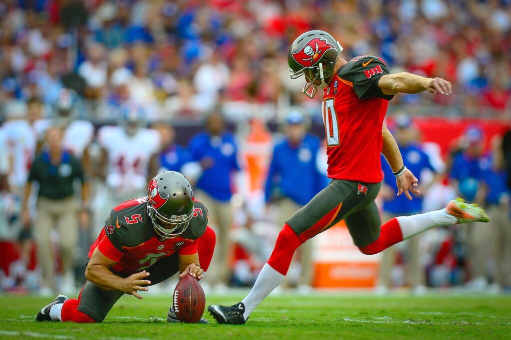 Football kicker and holder on the field